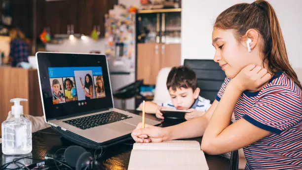 Teenage girl studying with video online lesson at home   family in isolation covid-19. Homeschooling and distance learning