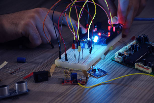 inżynier pracujący nad projektem arduino, deską do kroju, modułem elektronicznym - breadboard zdjęcia i obrazy z banku zdjęć