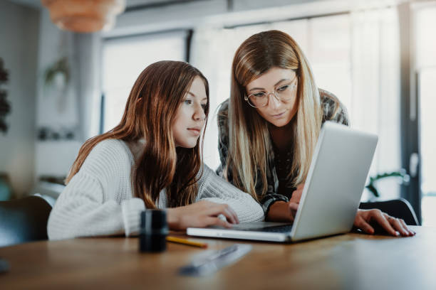istock Mother and child doing homeschooling, e-learning at home 1216393117