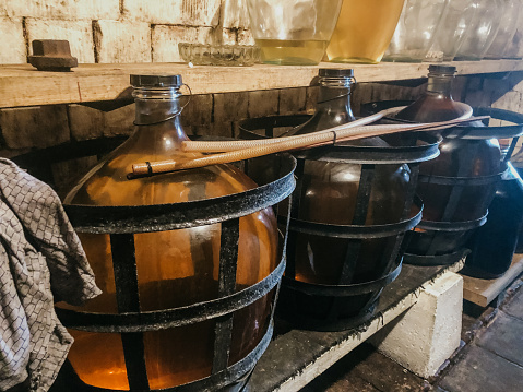 Row of carboys on a shelf for winemaking in a wine cellar, Moravia, Czech Republic