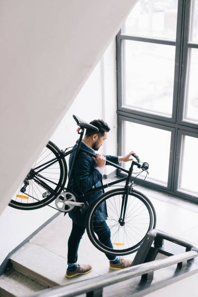 istock Man carrying bicycle up the stairs 1216394566
