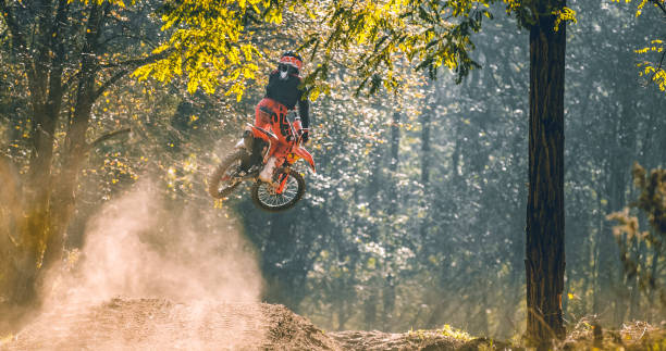 istock Motocross racer performing high jump in forest 1216396283