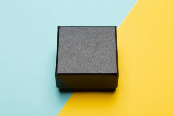 istock Mini black box product packaging isolated on yellow half blue background 1216397226