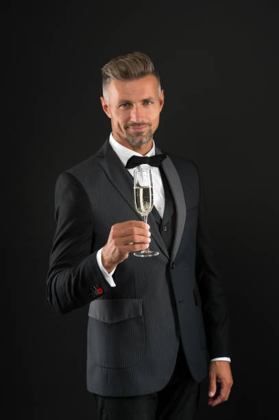 cheers. sincere greetings. appreciate classics. bearded man with formal look. hipster black background. brutal man in tuxedo suit. classic can make man look smarter. celebrate with champagne glass - haute couture beautiful smoking beauty imagens e fotografias de stock