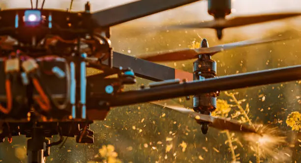Photo of Close-up of drone cutting plants with propellers