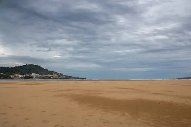 Photo of Castro Urdiales beach on a day with gray clouds.