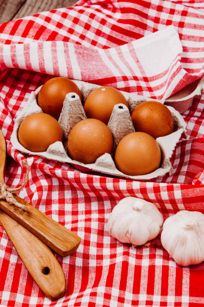 istock Wooden ladles, garlic and eggs on a red and white table rug 1216399183