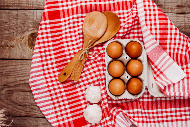istock Wooden ladles, garlic and eggs on a red and white table rug 1216399220
