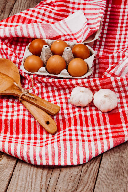 istock Wooden ladles, garlic and eggs on a red and white table rug 1216399232