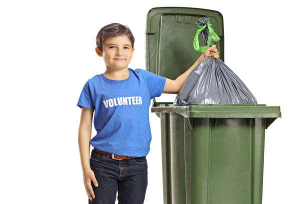 istock Child volunteer throwing a waste bag into a bin 1216400006