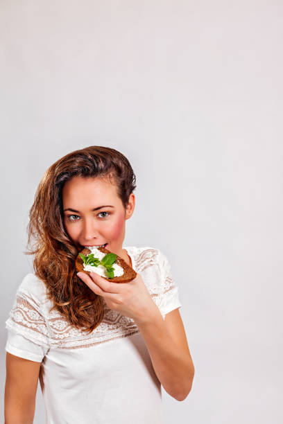 istock Woman eating bread with cream cheese 1216400459