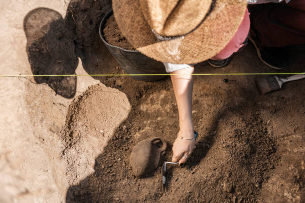 istock Archaeology - Archaeologist Digging Up Ancient Pottery 1216400582