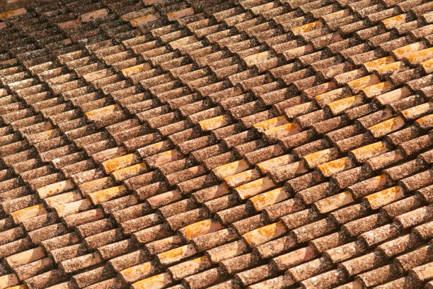 Close up shut of some dirty old roof tiles on a house.