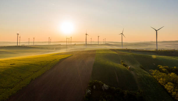 вид с воздуха на поля и ветровые турбины на восходе солнца, австрия - fog wind power energy fuel and power generation стоковые фото и изображения