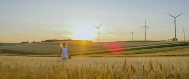 istock Woman walking in wheat field at sunset 1216403157