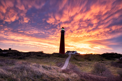 dramatic purple mammatus clouds over lighthouse at dawn, Schiermonnikoog