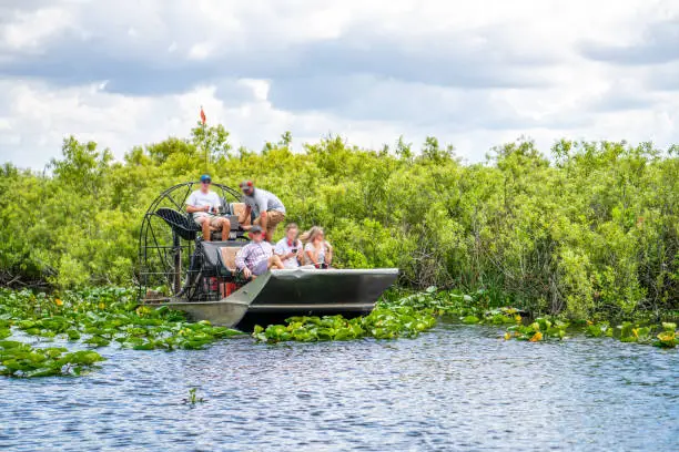 Photograph of a group of tourists in a hovercraft in the wetlands of Everglades National Park, Florida, USA