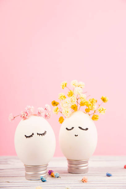 Portrait of an easter egg with flowers on pink background.