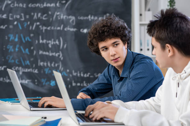 istock One of guys looking at his classmate while consulting about difficult point 1216409233