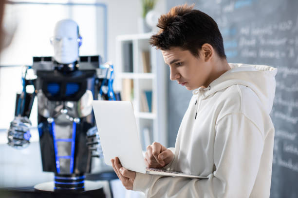 istock Serious teenager looking at laptop display while learning new software 1216409241