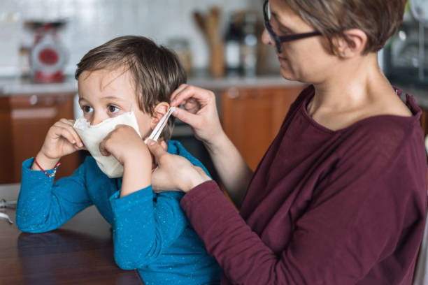 istock Mother making face mask for her little son 1216410702