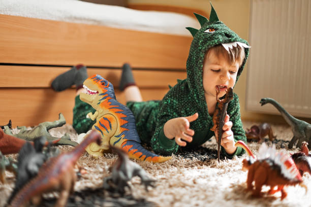 istock Adorable boy playing with his dinosaurs 1216411013