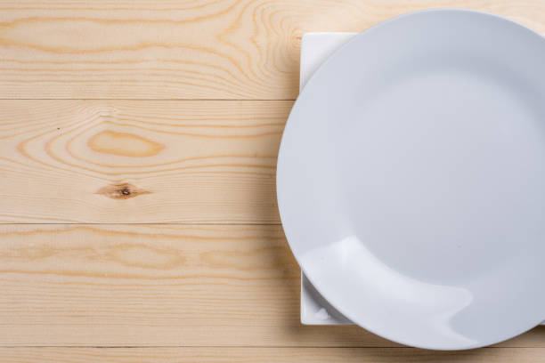 istock Flat lay above empty white plates on the wooden texture table with copy space 1216411480