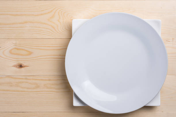 istock Flat lay above empty white plates on the wooden texture table with copy space 1216411490