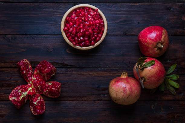 istock three pomegranate with bowl on real wooden table wonderful colors 1216414903
