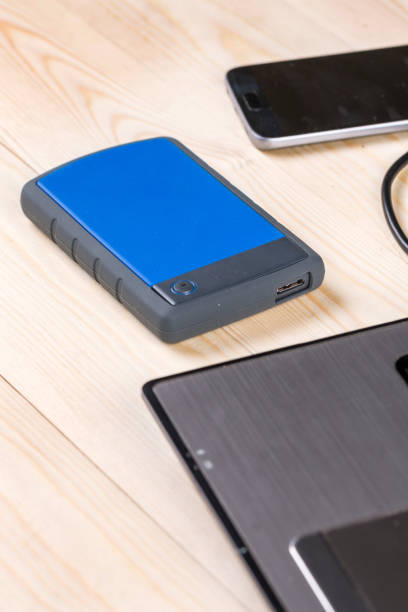istock External hard disc hdd on the wooden table with lap top computer and mobile phone 1216415177