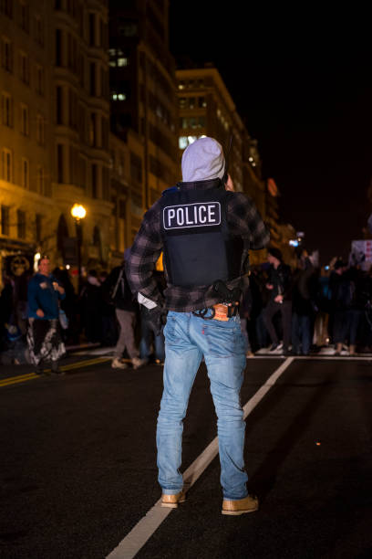 police officer in blue jeans monitoring a crowd - large group of people flash imagens e fotografias de stock