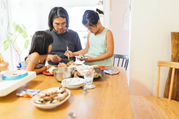 istock Father preparing food with her daughters at home 1216416651
