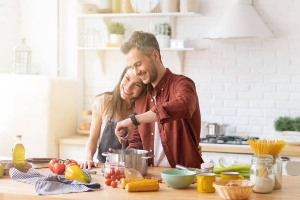 Happy smiling family couple cooking on kitchen