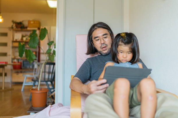 istock Father helping his daughter with e-learning on digital tablet at home 1216417713
