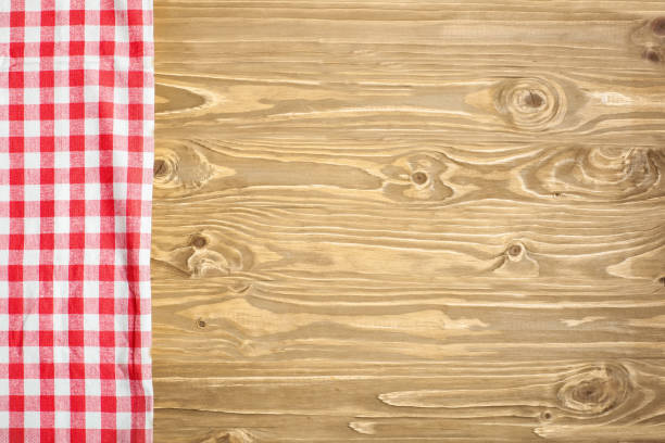 istock Red checkered tablecloth on wooden table. Background with copy space. Horizontal. Top view. 1216418470