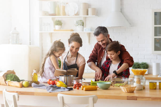 家庭のキッチンで一緒に幸せな家族の料理 - mother son family cooking ストックフォトと画像