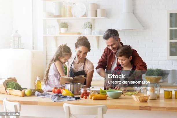 Happy Family Cooking Together On Home Kitchen Stock Photo - Download Image Now - Family, Cooking, Healthy Eating