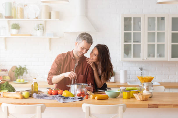 istock Happy couple cooking dinner together on kitchen 1216419406