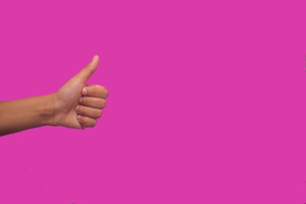istock Thumbs up gesture against neon pink background 1216420499