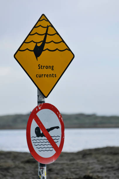istock Sign warning of strong currents, and prohibiting swimming. 1216423643
