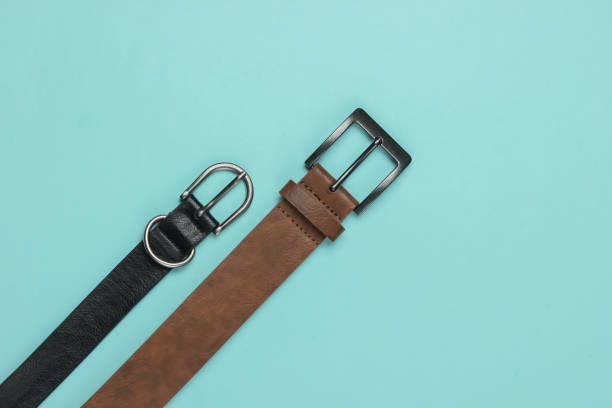 istock Two leather belts on a blue background close-up 1216424110