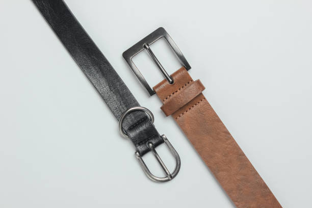 istock Two leather belts on white background close-up 1216424184