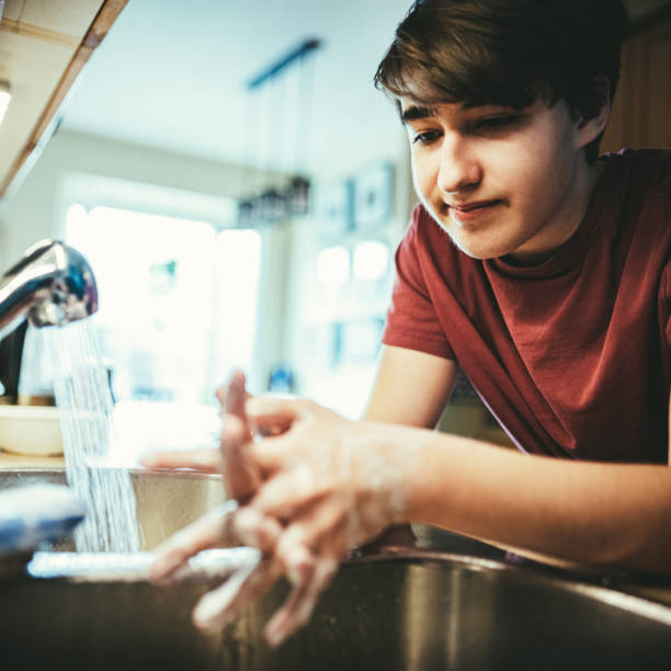 istock COVID-19, Teenager washing hands during lockdown 1216425151