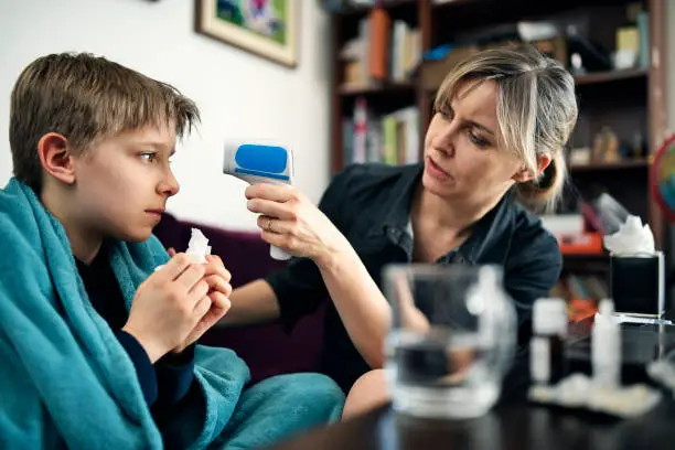 Photo of Mother and son on telemedicine video call with doctor