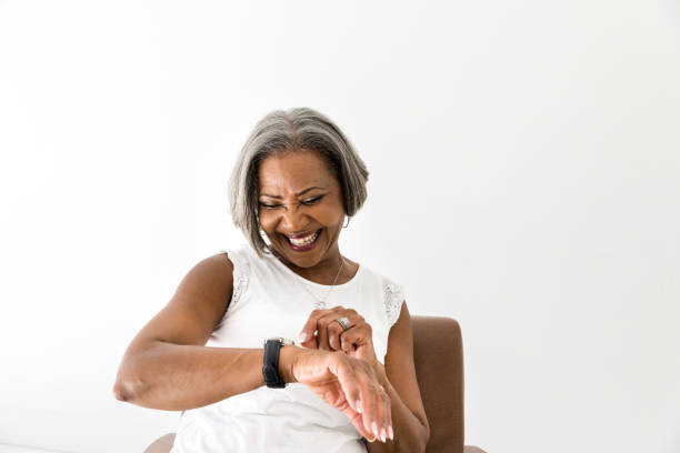 istock Happy woman smiles while looking at her watch 1216426299