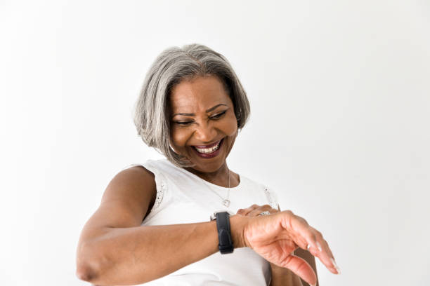 istock Smiling senior woman looking at watch 1216426301