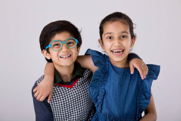 istock Excited brother and sister looking at camera over white background 1216426611