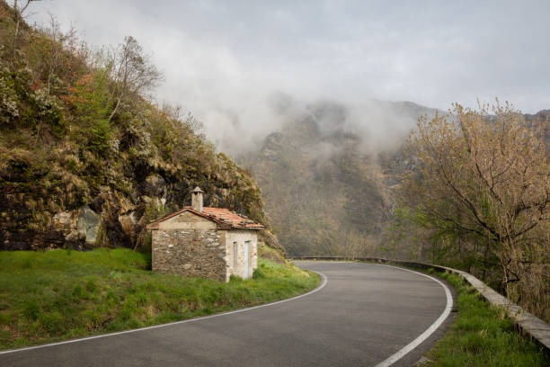 Toscany in the mist, a road going around the bend towards the mist stock photo