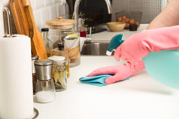 istock Man cleaning a white kitchen countertop 1216428479