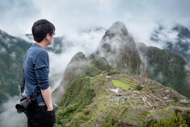 istock Young Asian man traveler looking at Machu Picchu 1216430902